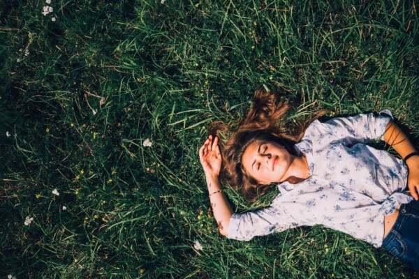 woman lying on grass during daytime