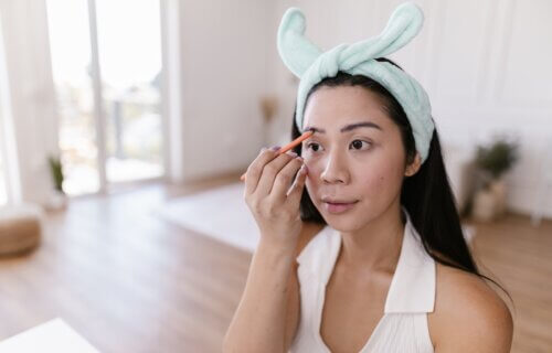 A woman using an eyebrow pencil