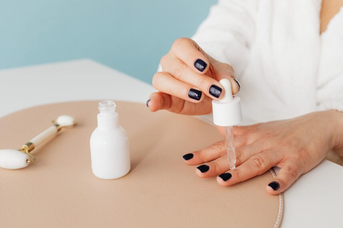 Woman applying oil to cuticles
