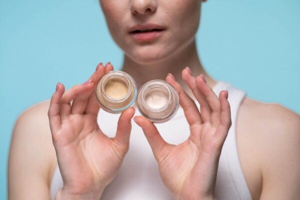 Woman holding jars of color corrector