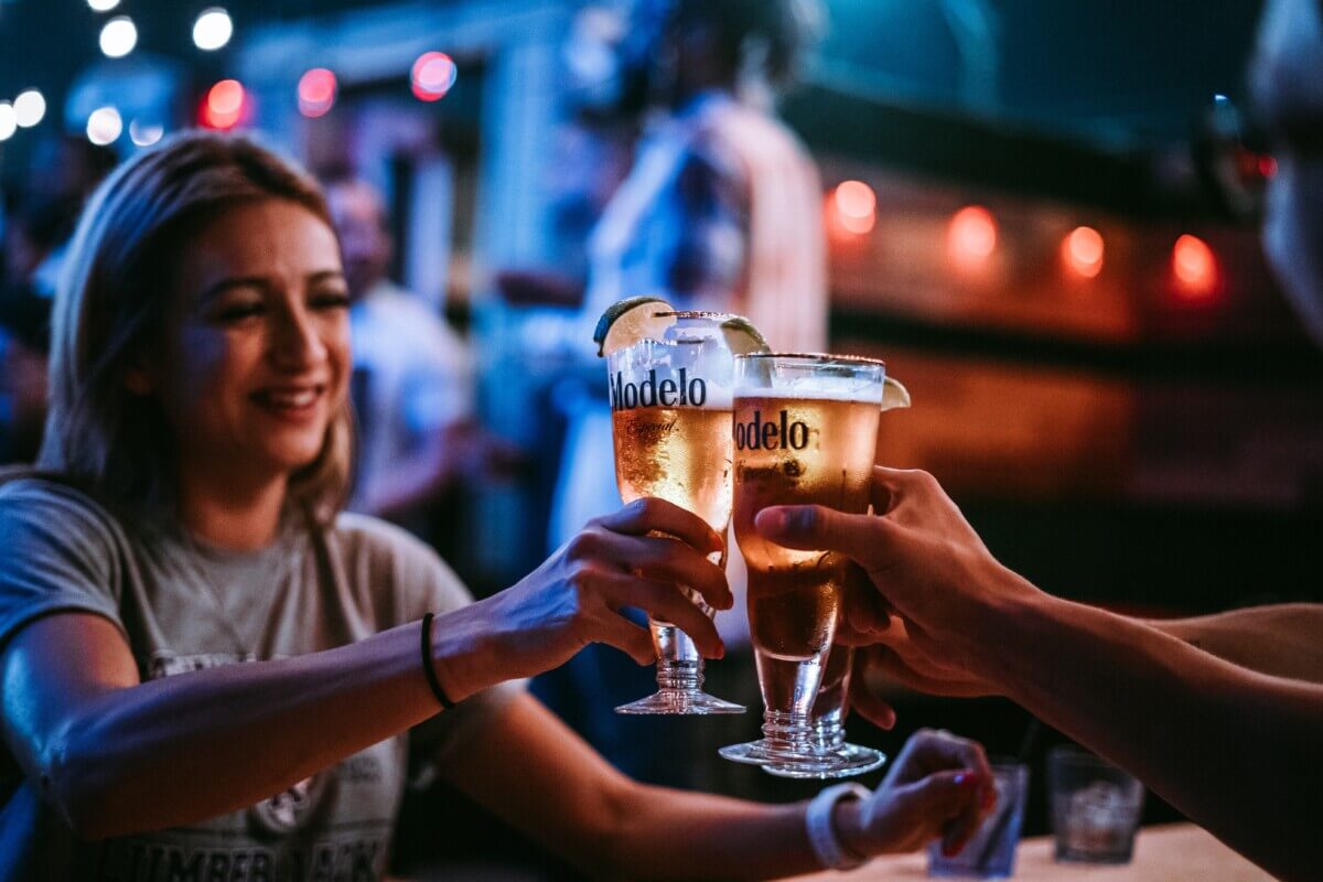 People clinking Modelo beer glasses