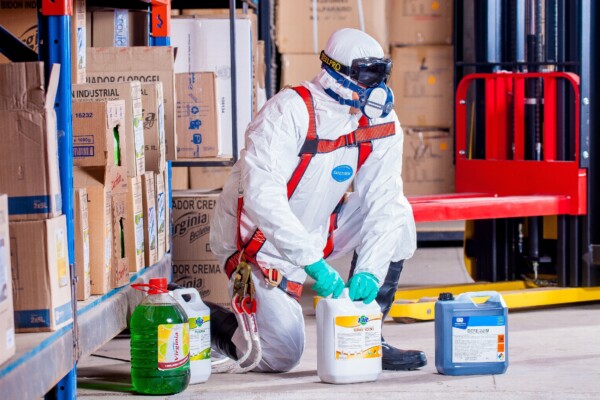 Worker in protective clothing handling chemicals