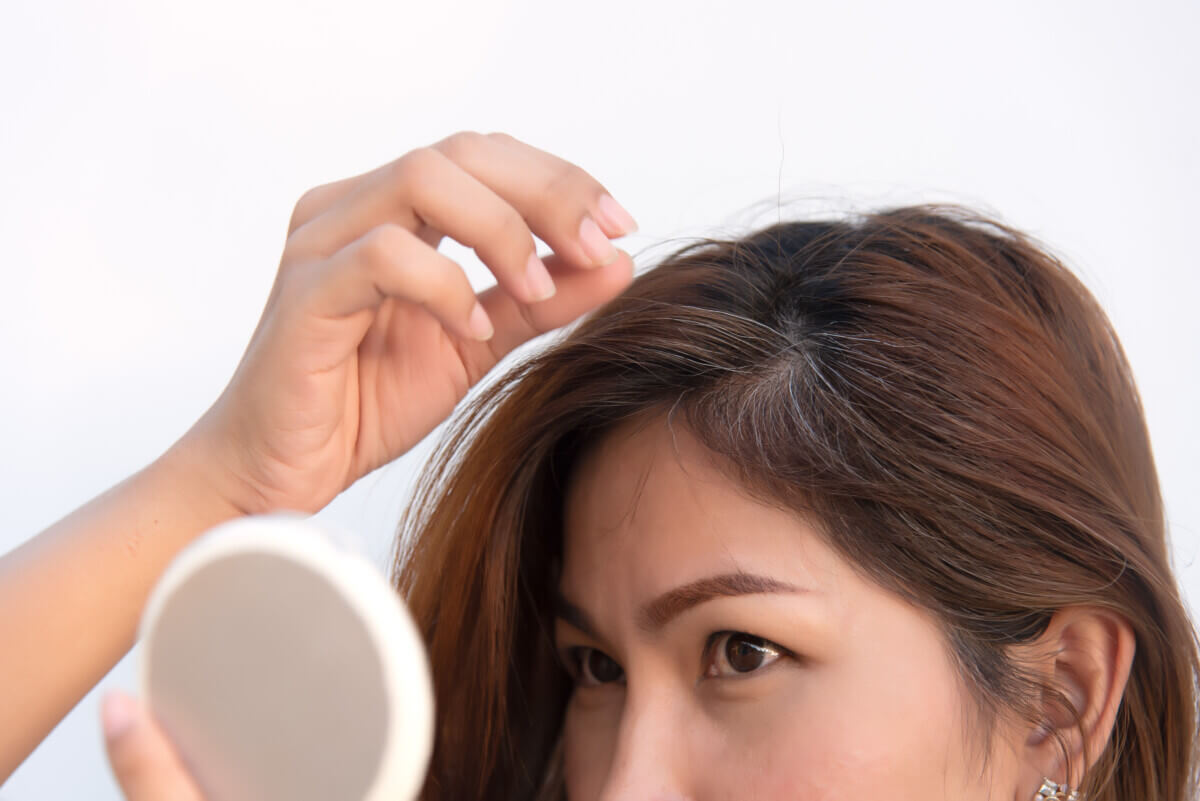 Woman looking at her gray roots