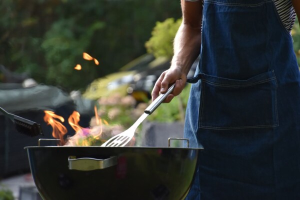 A man cooking on a charcoal grill outside