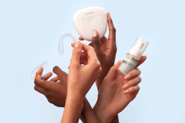 three hands holding teeth whitening products