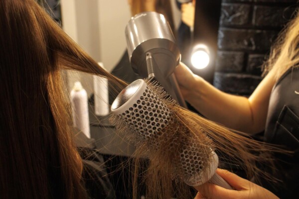 A hairdresser drying someone's hair