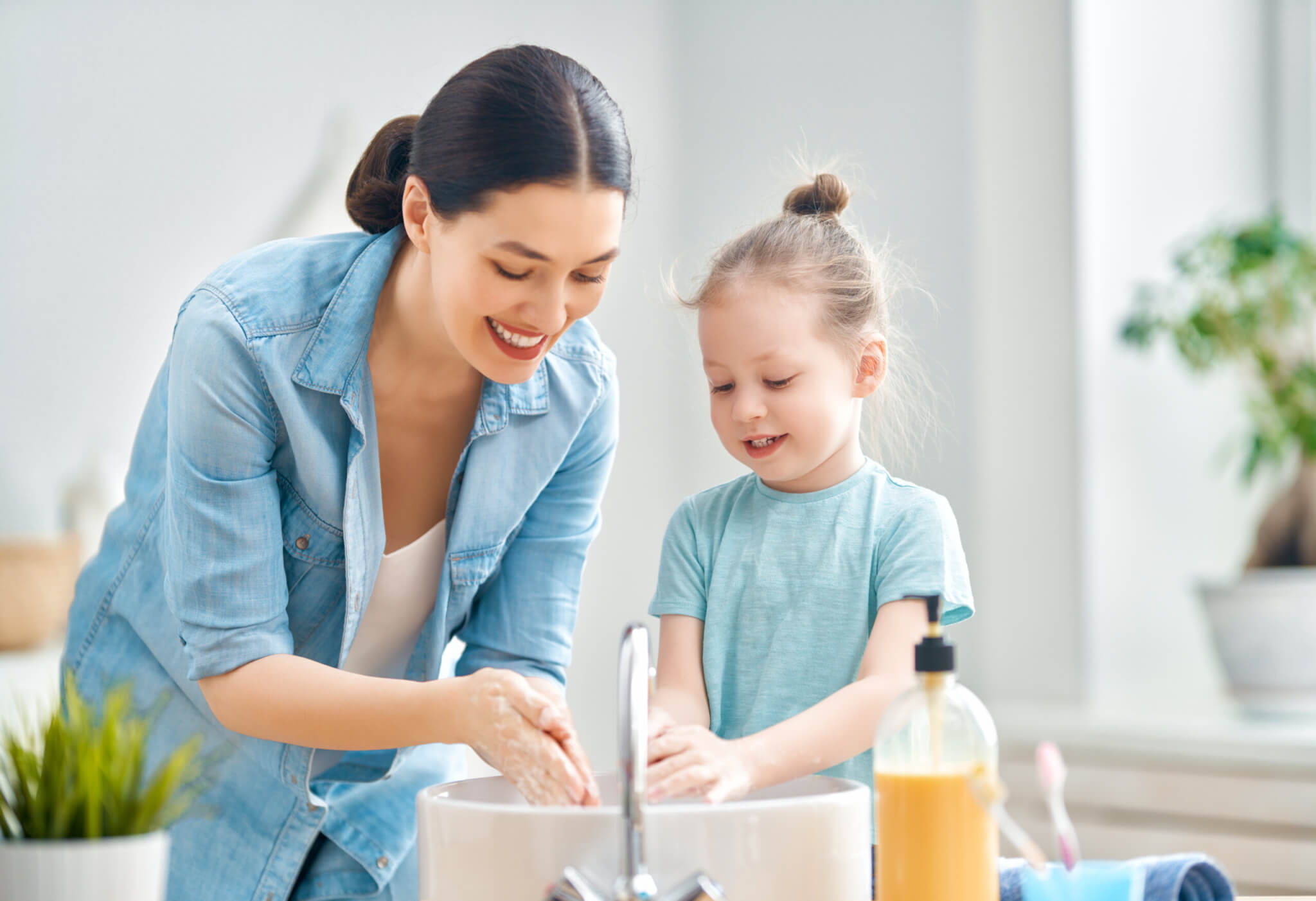 Mother and daughter washing their hands