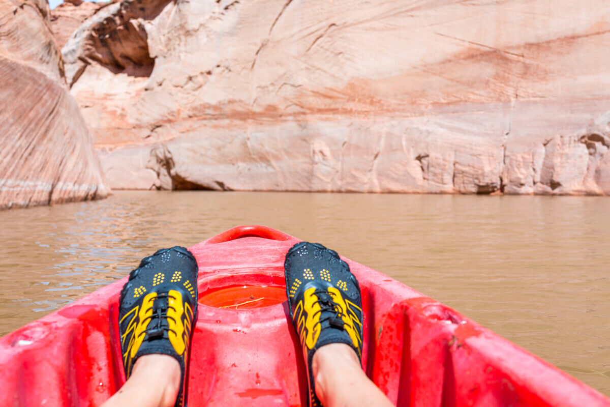 Someone kayaking wearing water shoes