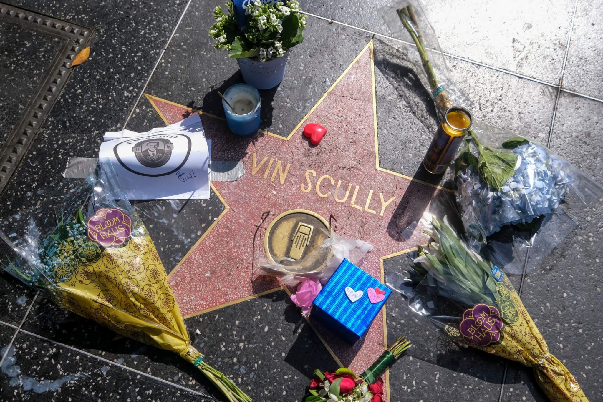 Flowers, candlelights and messages are displayed at the star of broadcaster Vin Scully on the Hollywood Walk of Fame in August 2022 
