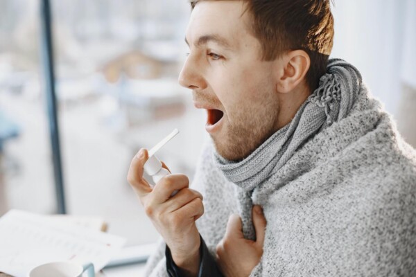 A man using throat spray