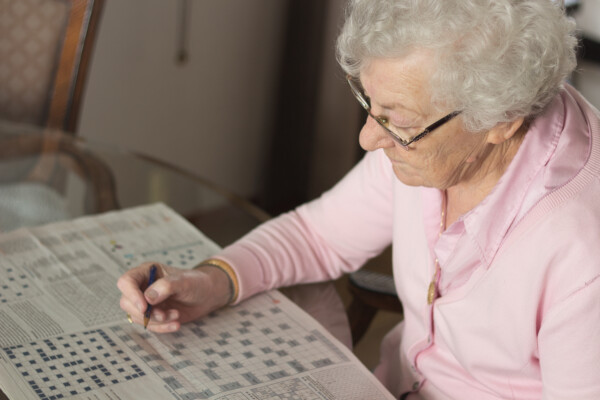 Older woman doing a crossword puzzle.