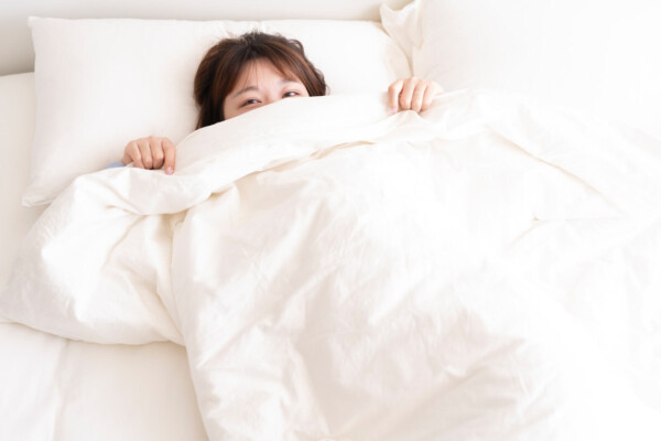 Little girl under the covers in bed