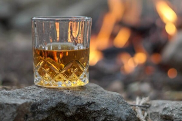 A glass of Scotch near a bonfire