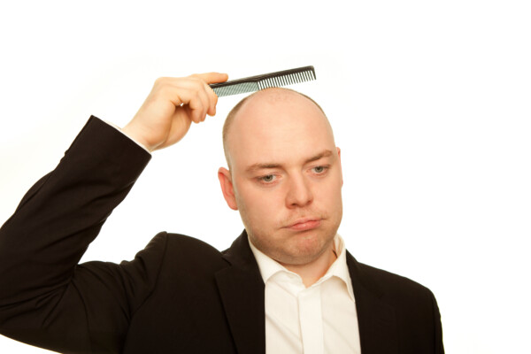 business man with comb is sad about hair loss