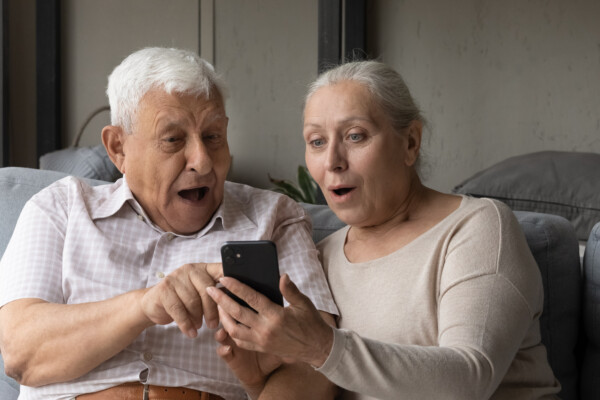 retired couple looking at game on cellphone