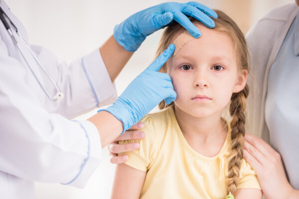 Doctor examining child head injury