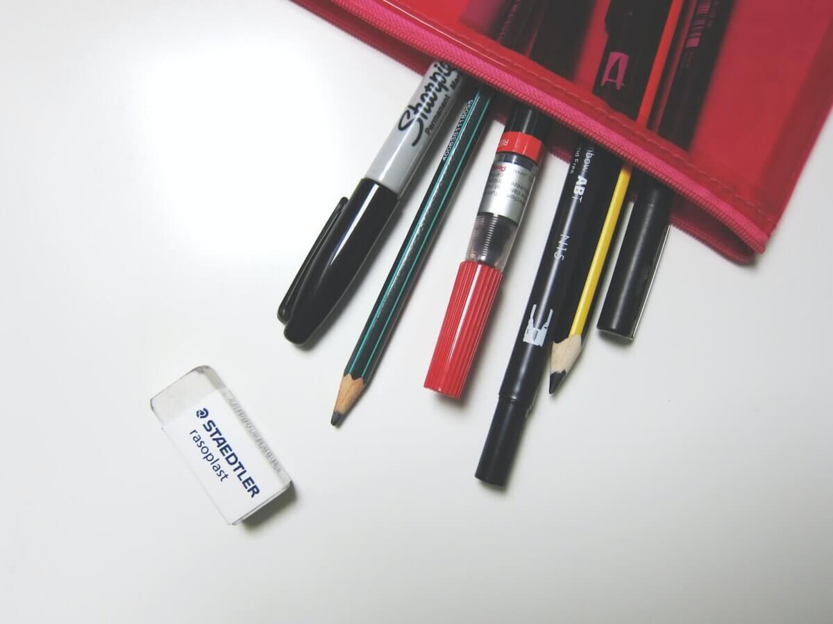 Pencils and pens spilling out of a pencil case