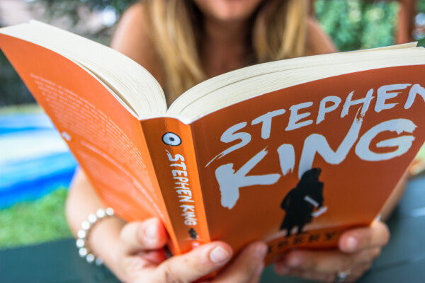 A woman reading "Misery" by Stephen King