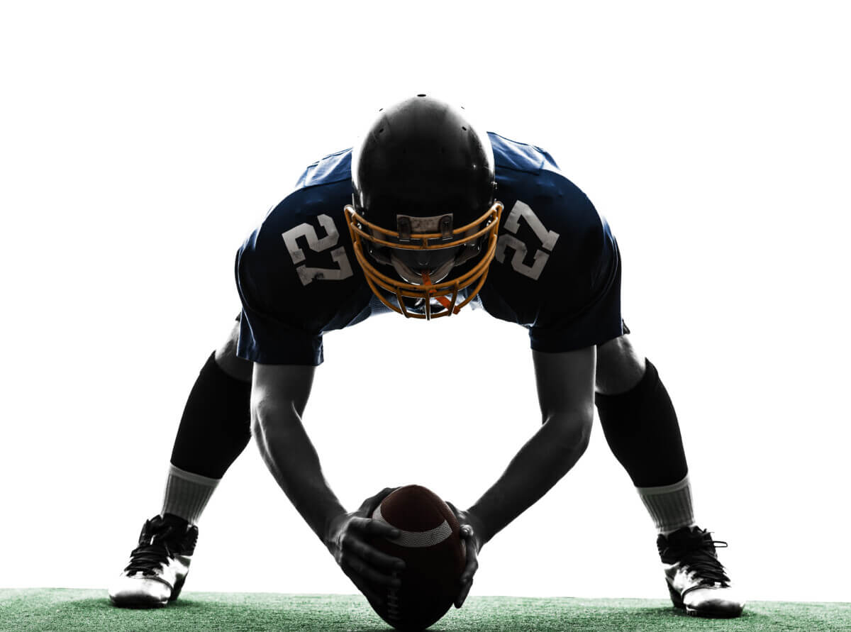 A football center preparing to snap the ball