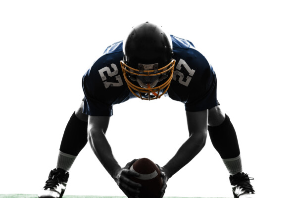A football center preparing to snap the ball
