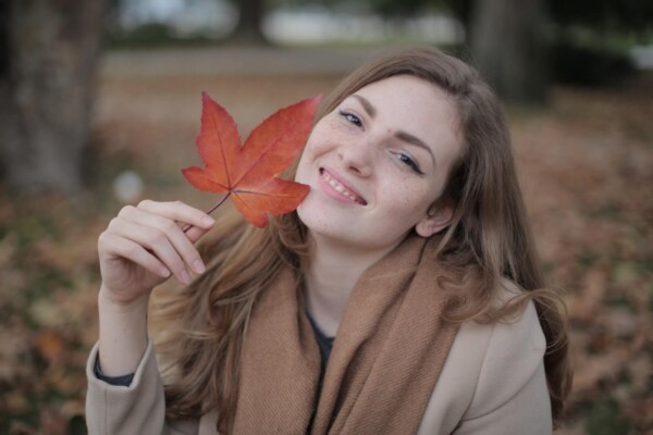 A woman holding a fall leaf