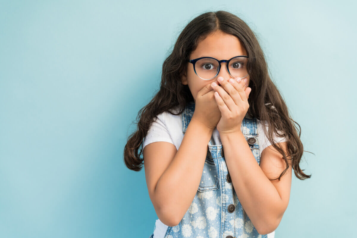 Surprised little girl covering her mouth