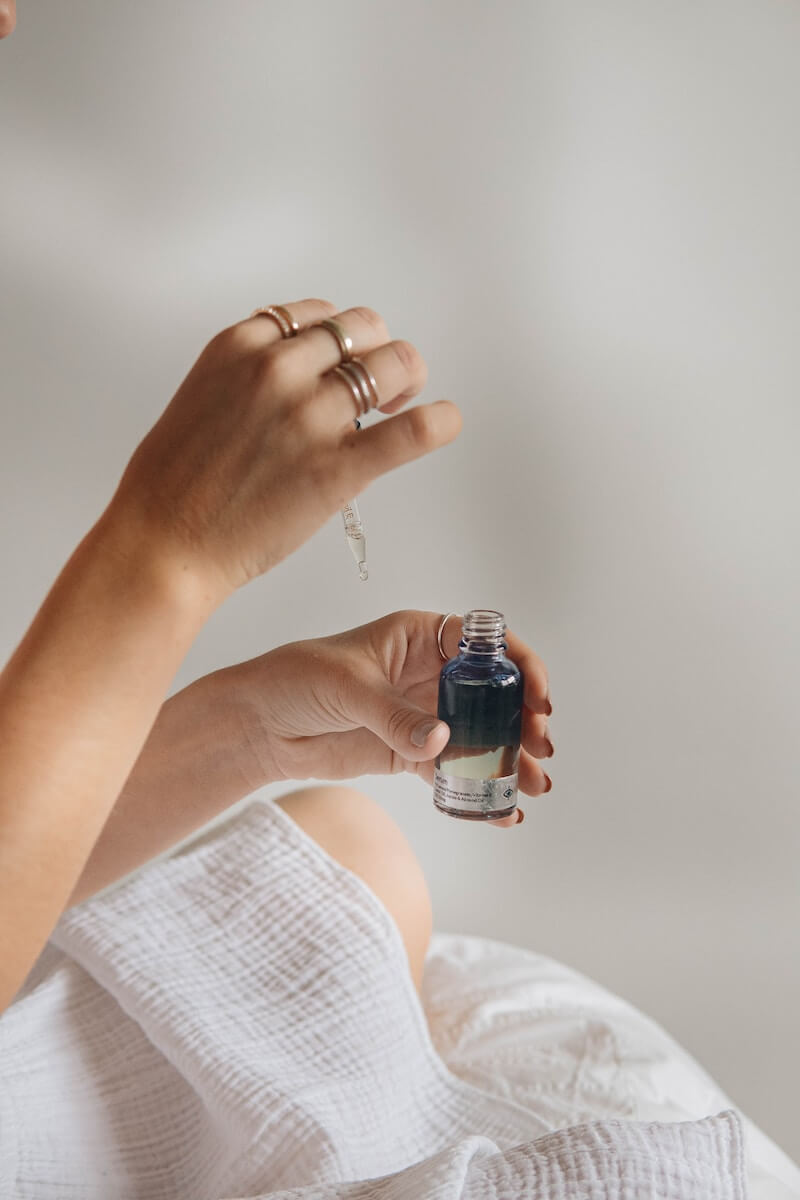 Someone holding a bottle of serum