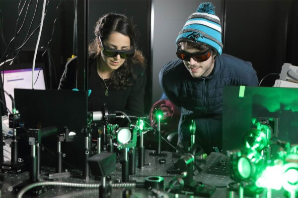 Doctoral candidates Sara Makarem Hoseini and Daniel Hirt observe the plasma ray setup.