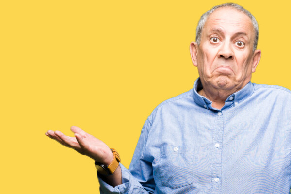 A senior man shrugging