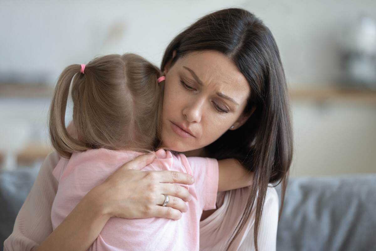 Worried mother hugging her child