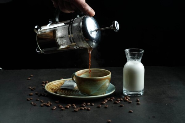 Someone pouring a cup of French press coffee