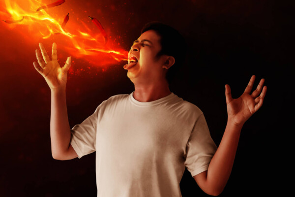 A man breathing fire from hot sauce