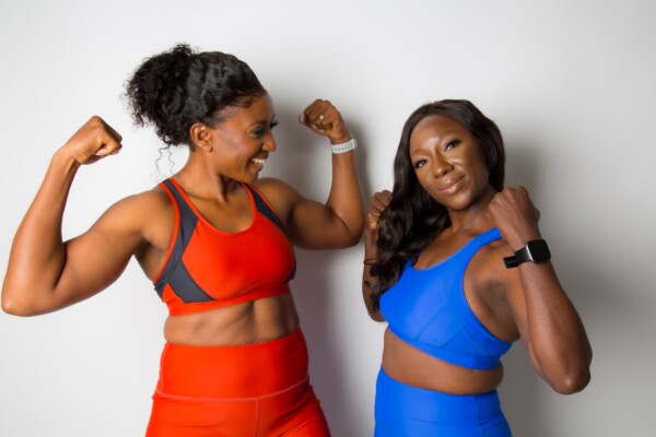 Two women wearing sports bras and leggings