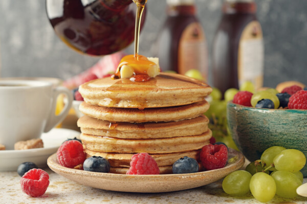 Syrup pouring on a stack of pancakes