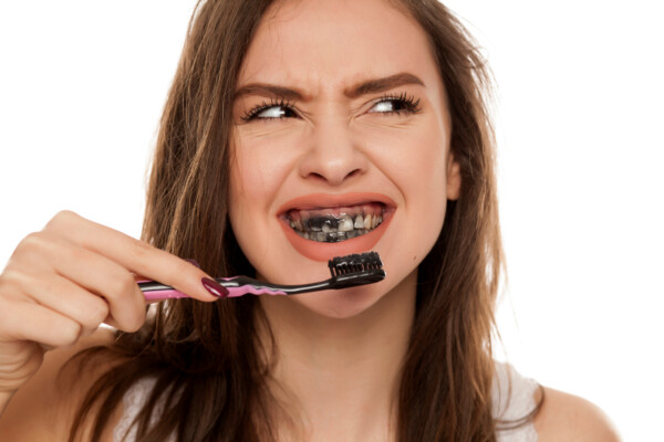 A woman using charcoal toothpaste