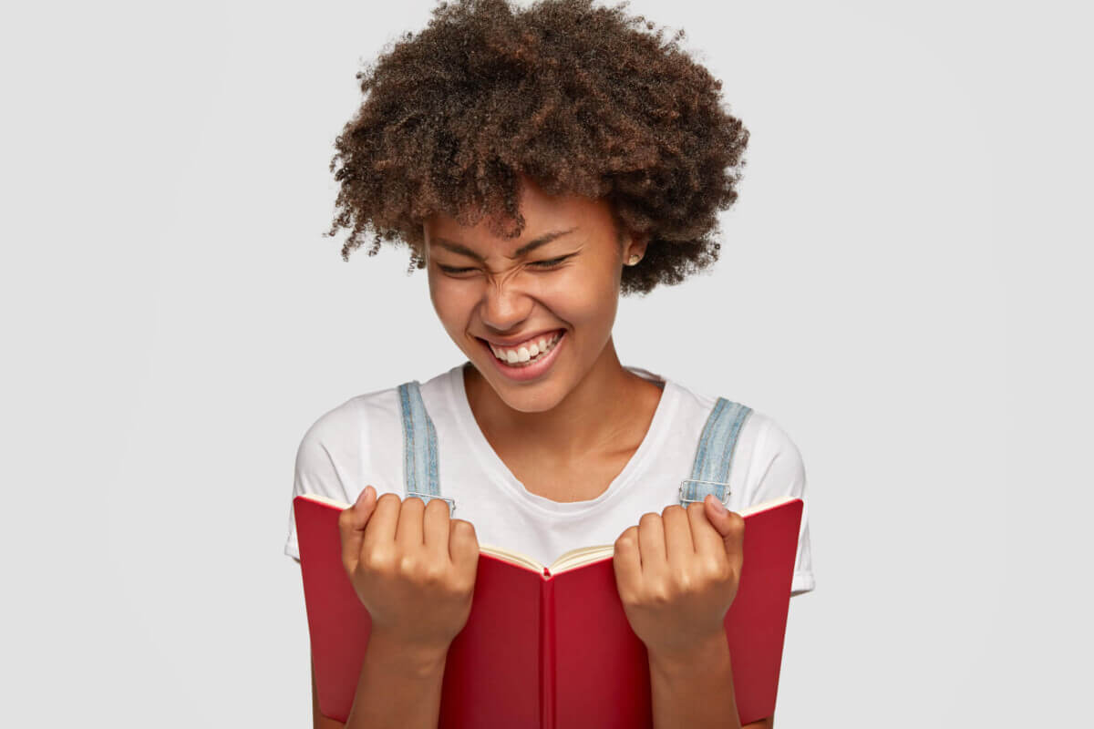A teenager laughing at a book