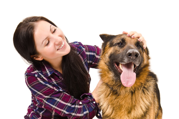 A woman petting a German Shepherd