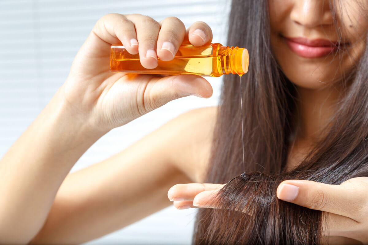 A woman applying hair oil