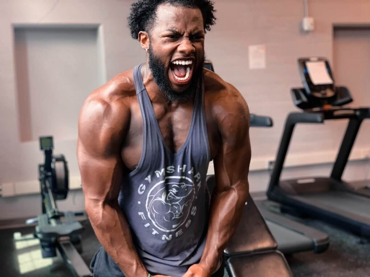 Man excited, flexing his muscles after working out at the gym