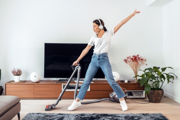 Woman cleaning living room to music