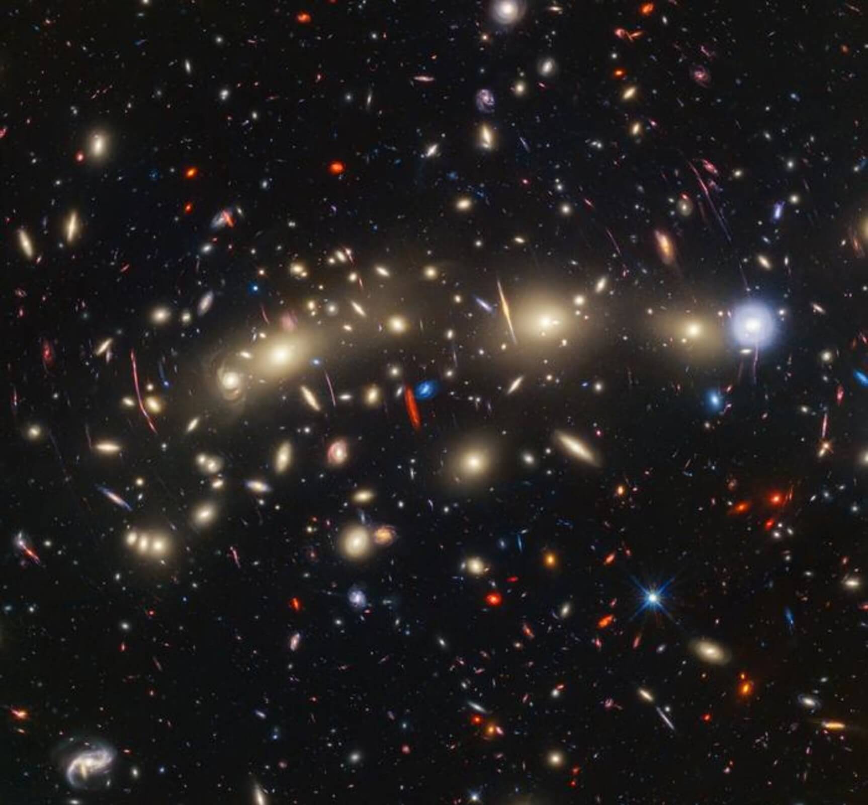 This panchromatic view of galaxy cluster MACS0416 was created by combining infrared observations from NASA’s James Webb Space Telescope with visible-light data from NASA’s Hubble Space Telescope