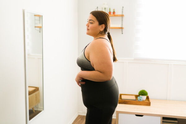 Obese woman looking in the mirror