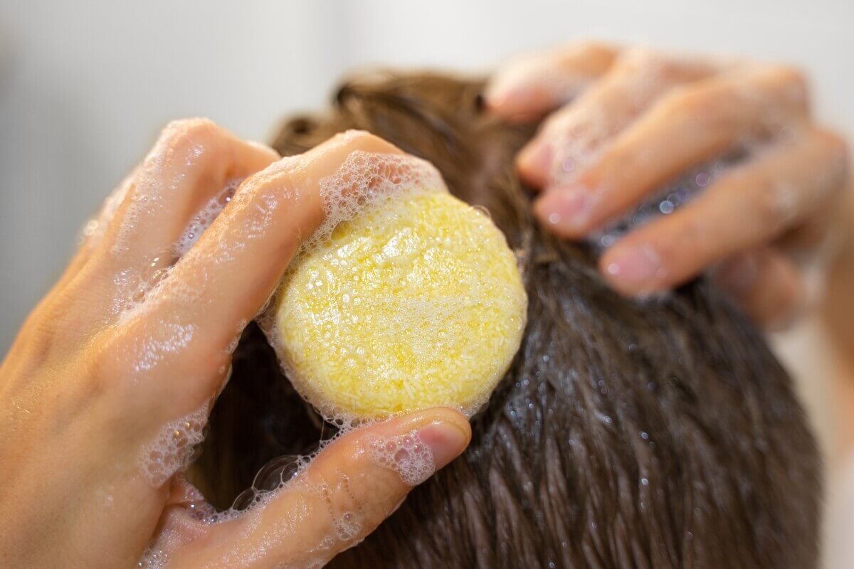 A man washing his hair with a shampoo bar