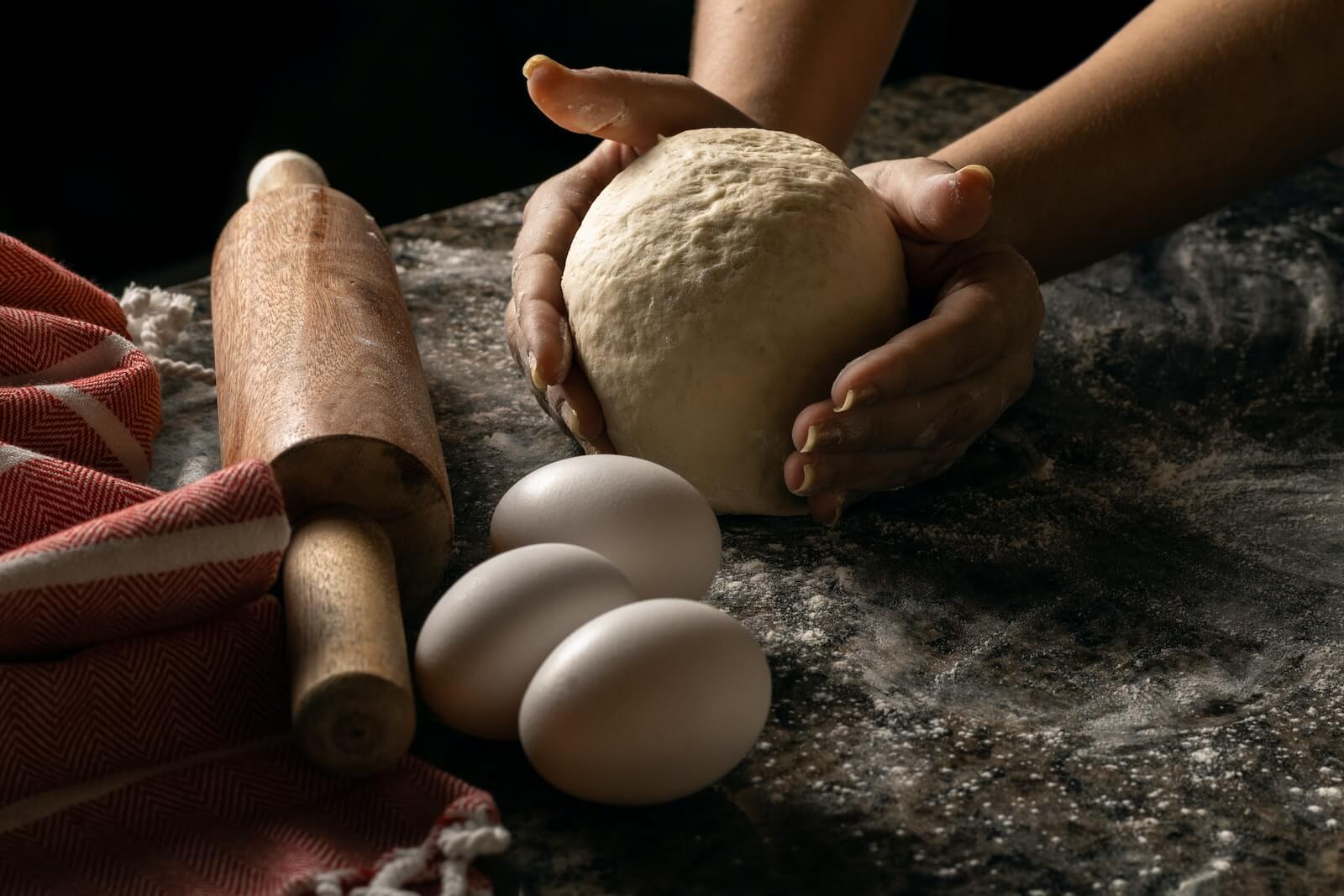 Someone kneading pizza dough
