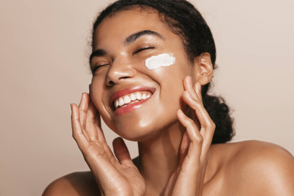 A woman applying facd moisturizer