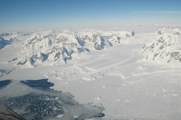 Ice on the Antarctic peninsula flowing along a channel into an ice shelf in the ocean.