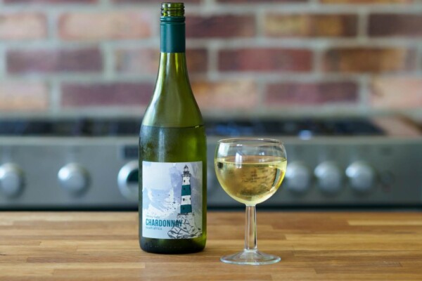 a bottle of Chardonnay wine next to a glass of wine. Photo by Brett Jordan on Unsplash