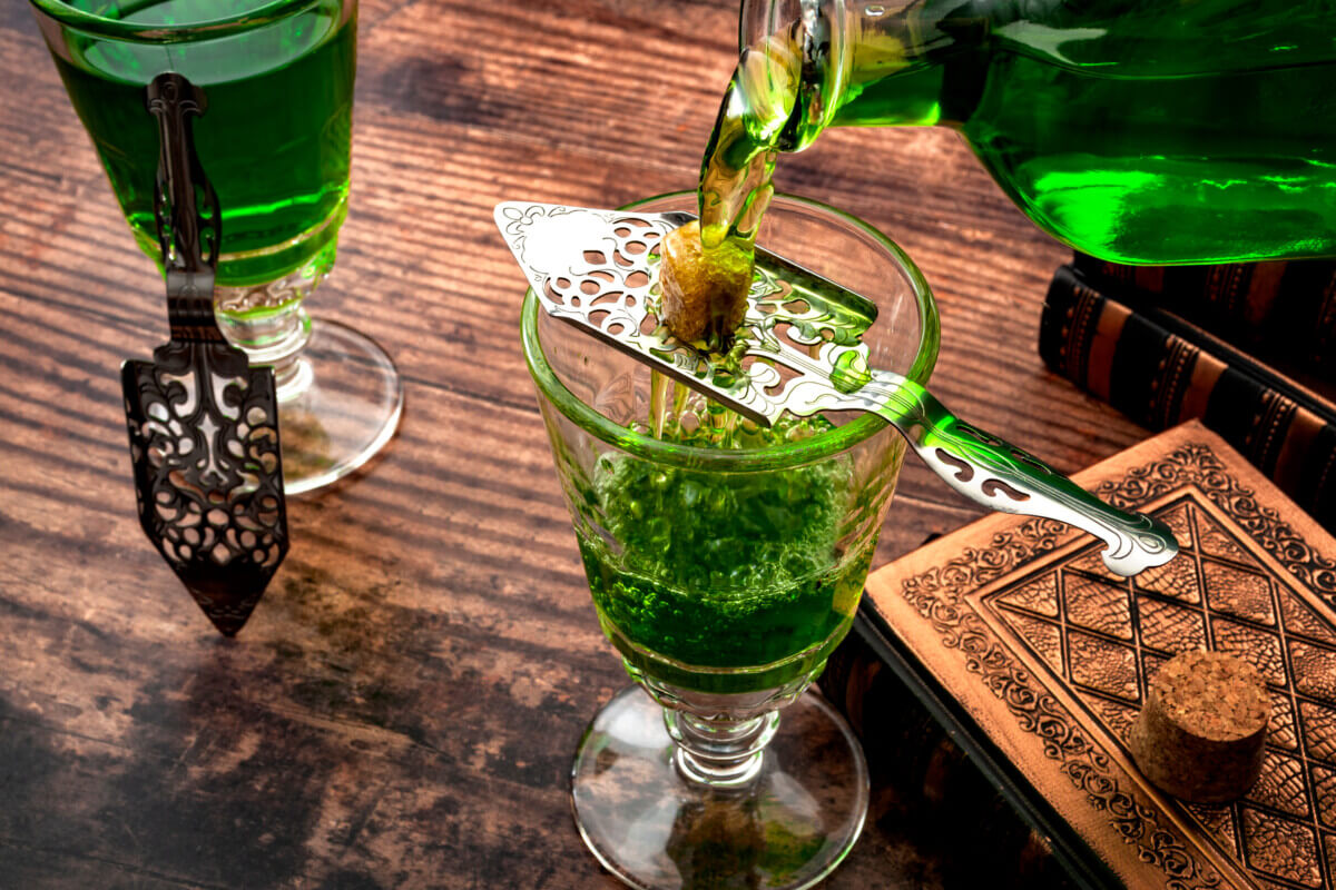 Someone pouring absinthe over a sugar cube