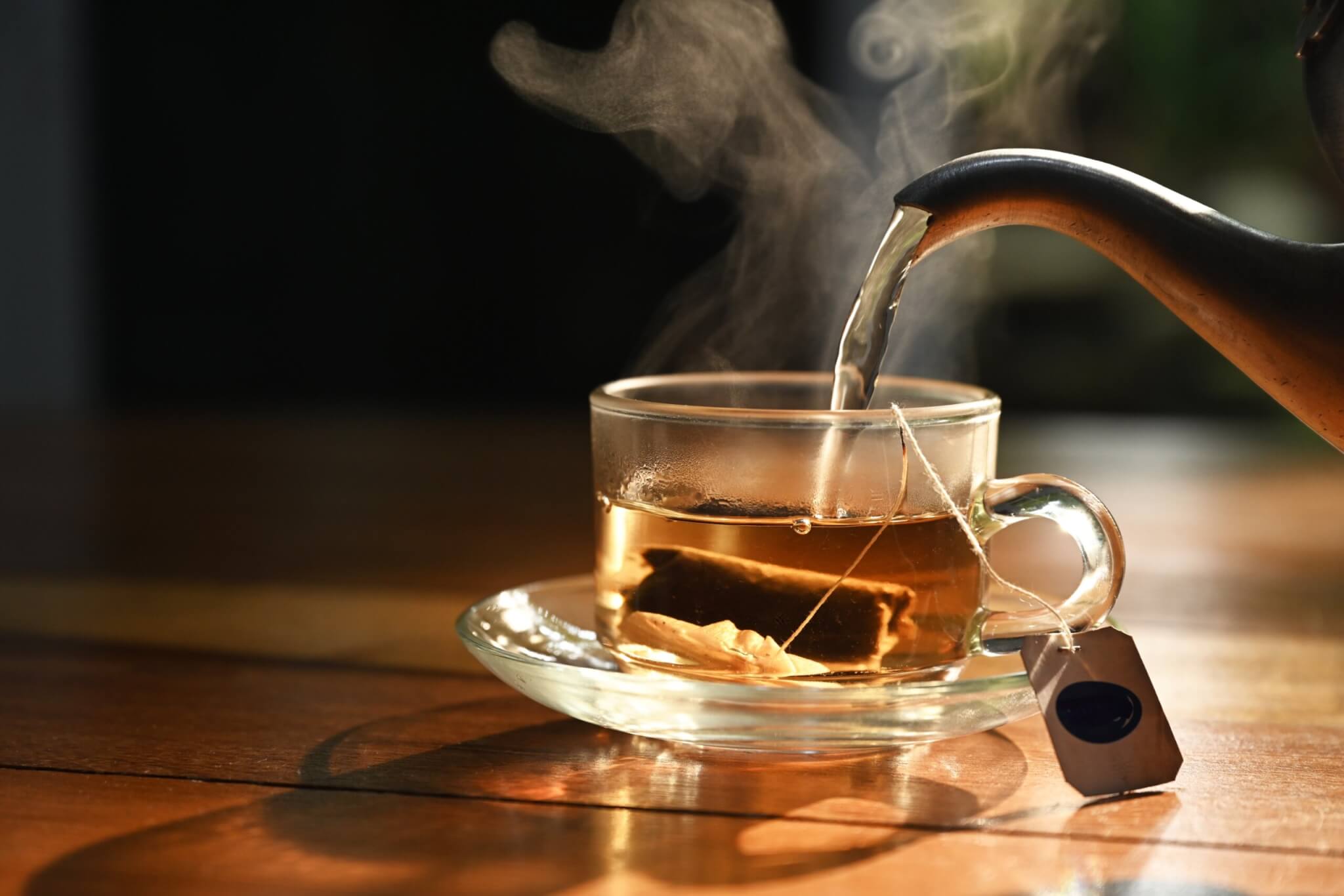 Someone pouring a cup of hot tea