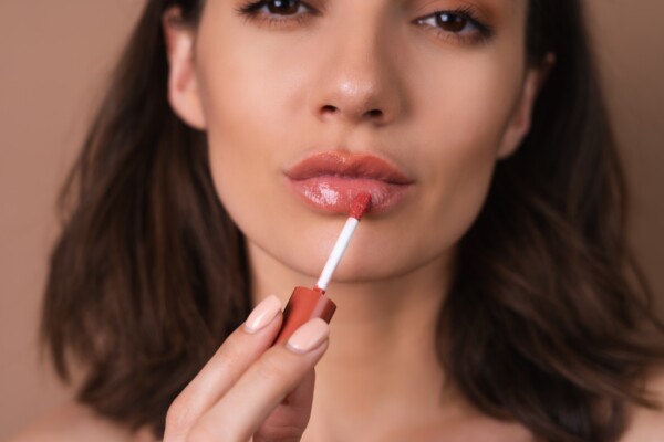 A woman applying lip oil